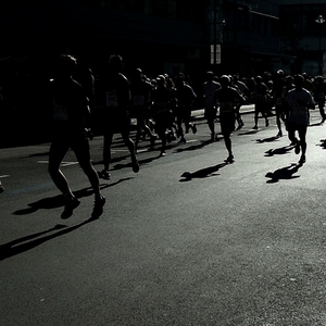 Runners wearing Herron running shorts during a night race on city street.